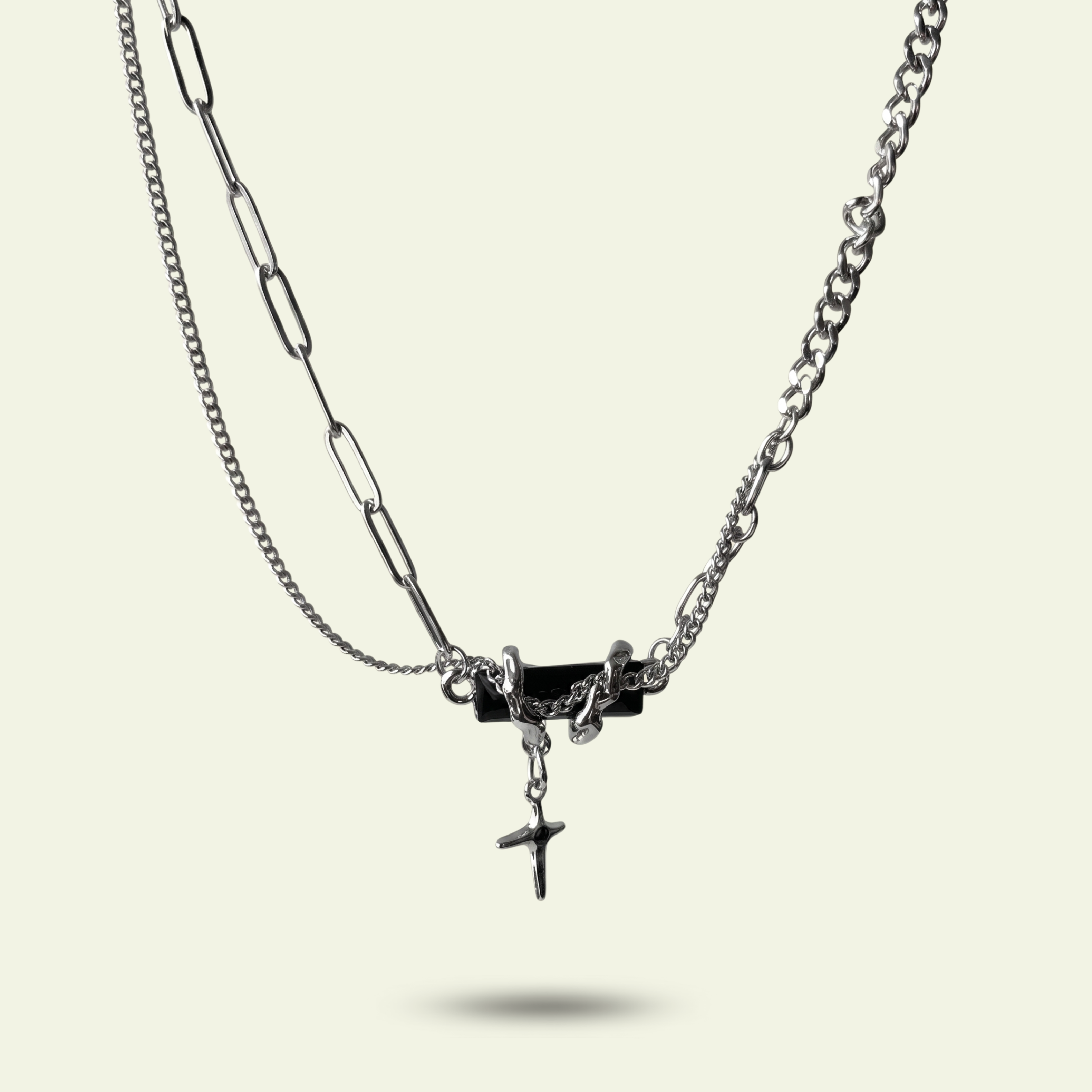 Double-layered necklace with chain and pendant on a light beige background