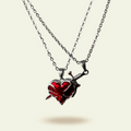 Heart-shaped pendant with red stone and silver chain on a white background
