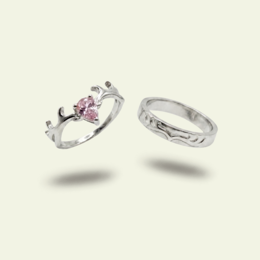 Two silver rings with a pink gemstone on a light gray background
