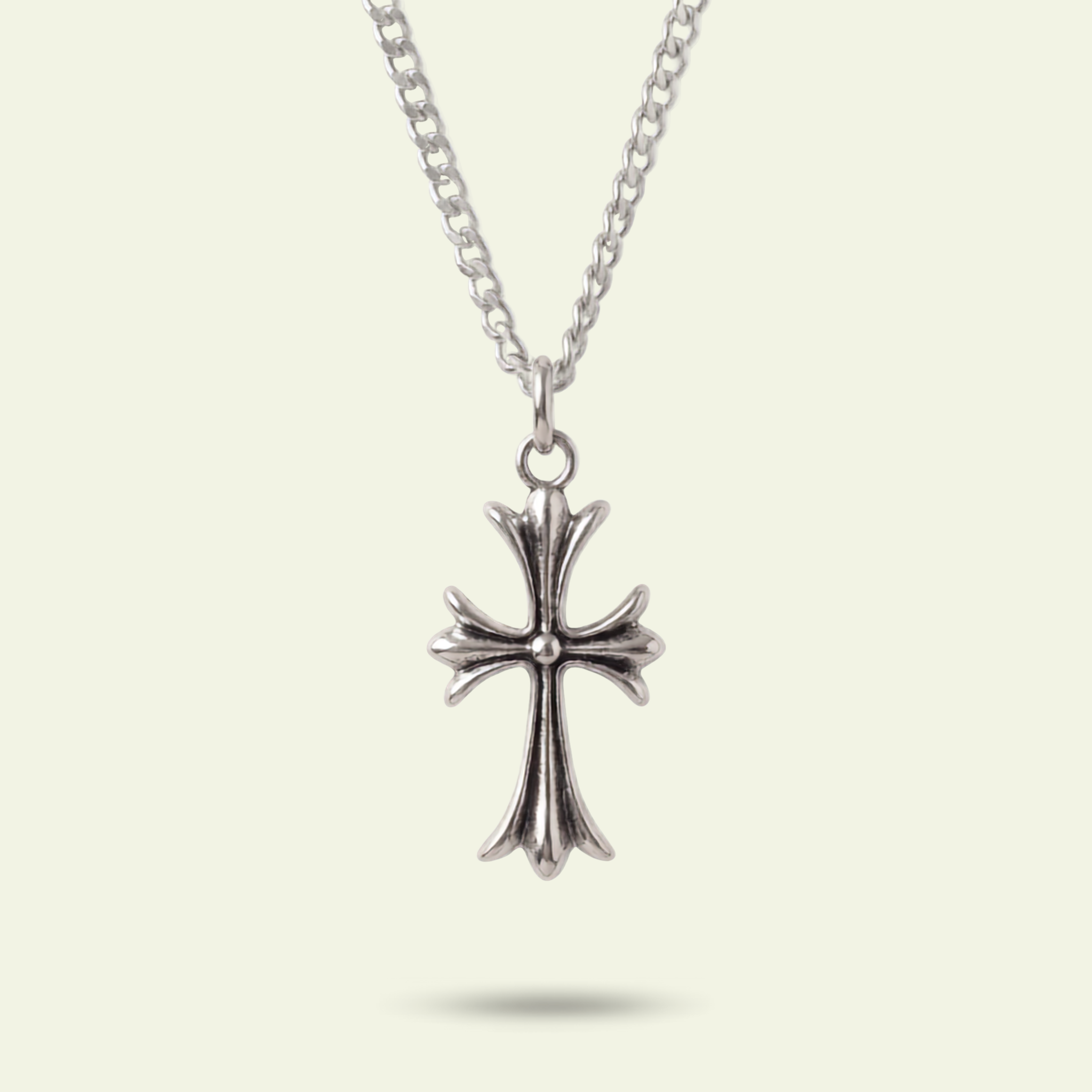 Silver cross pendant necklace on a light beige background