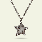 Star-shaped pendant on a chain against a light background