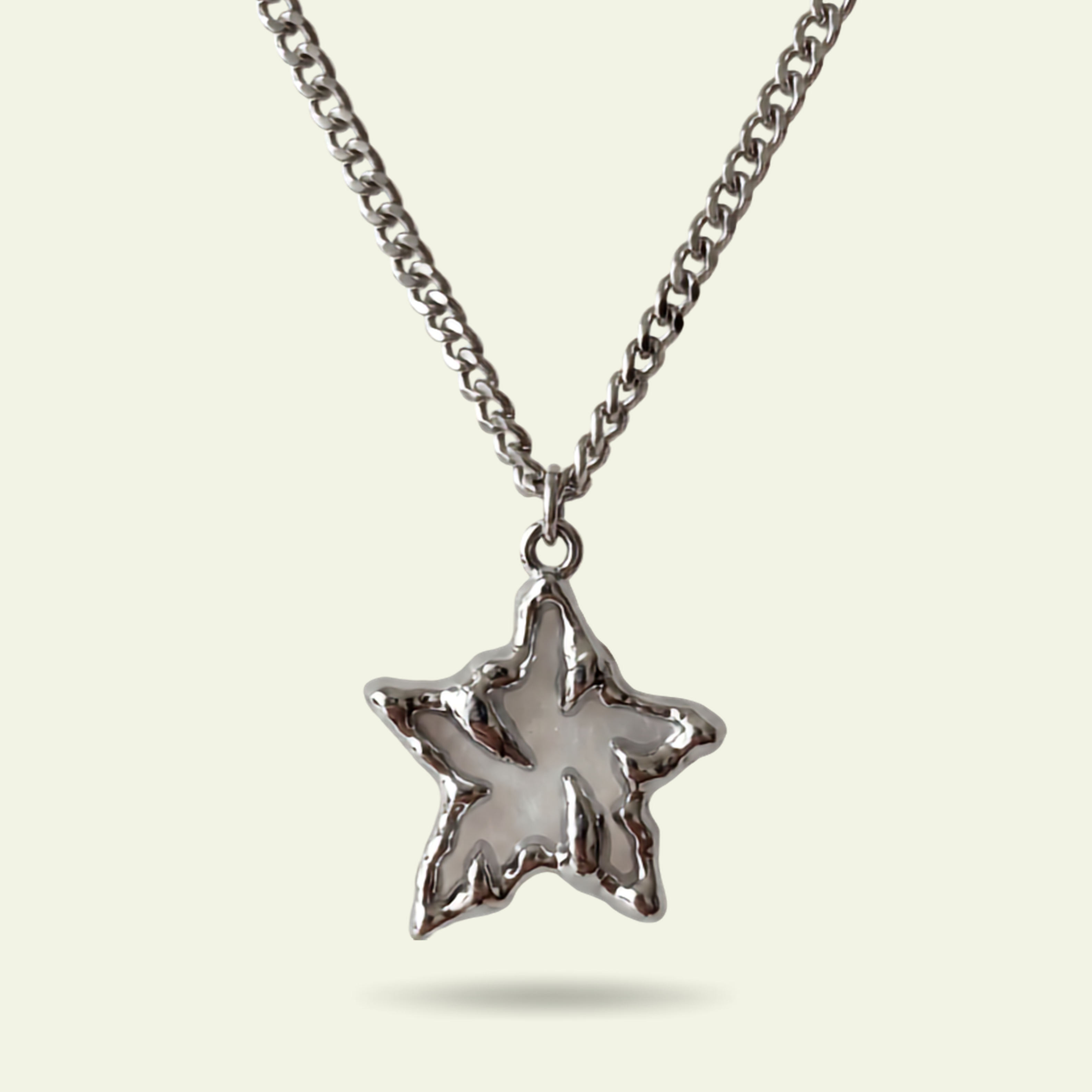 Star-shaped pendant on a chain against a light background