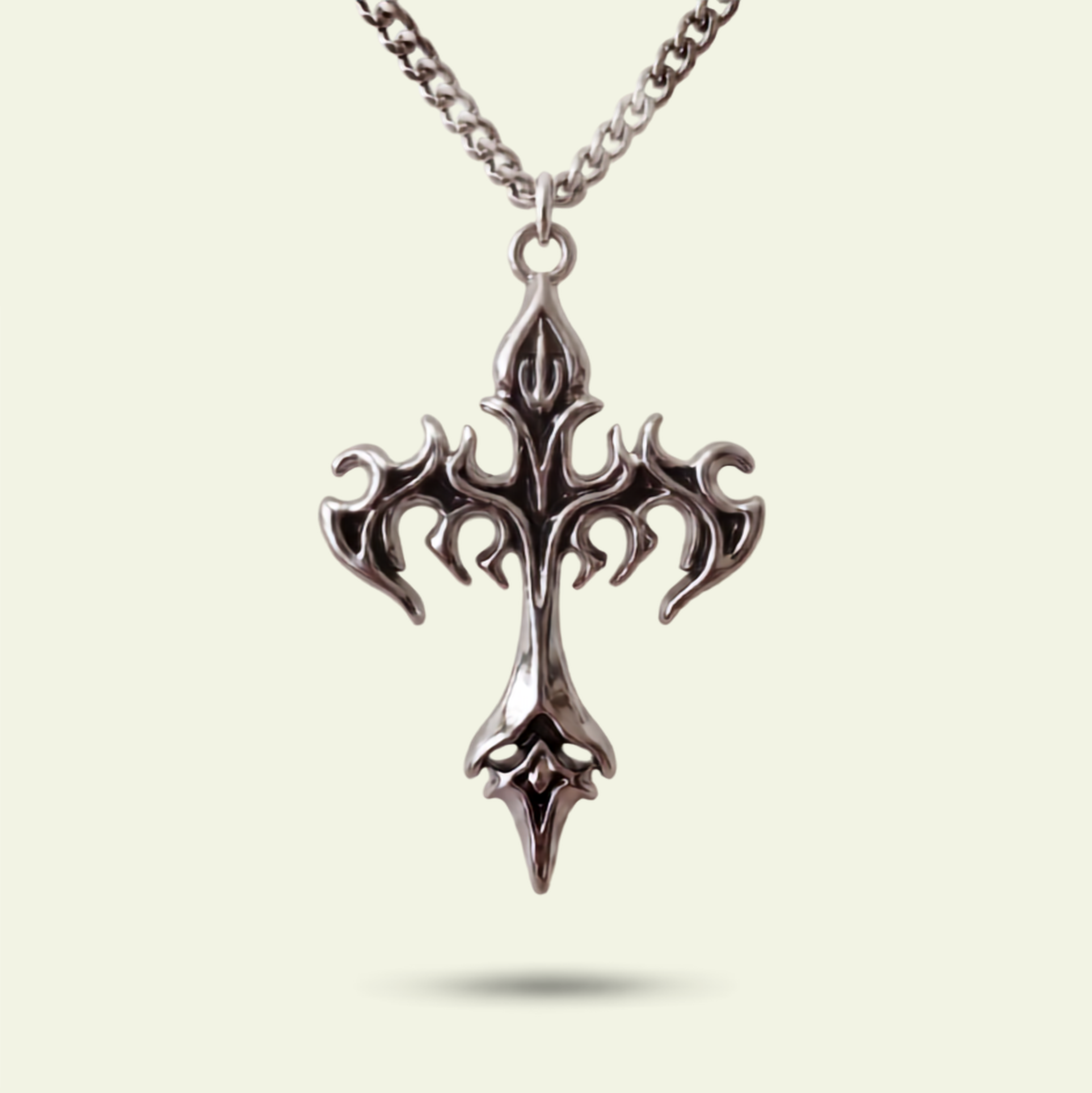 Silver cross pendant necklace on a light beige background