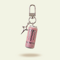 Pink Monster energy drink can keychain on a light beige background