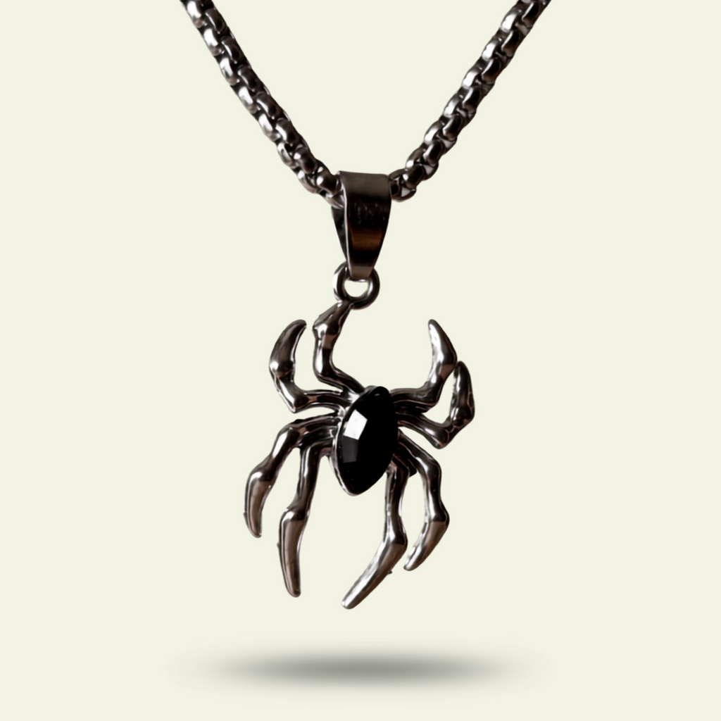 Spider-shaped pendant on a chain against a light background