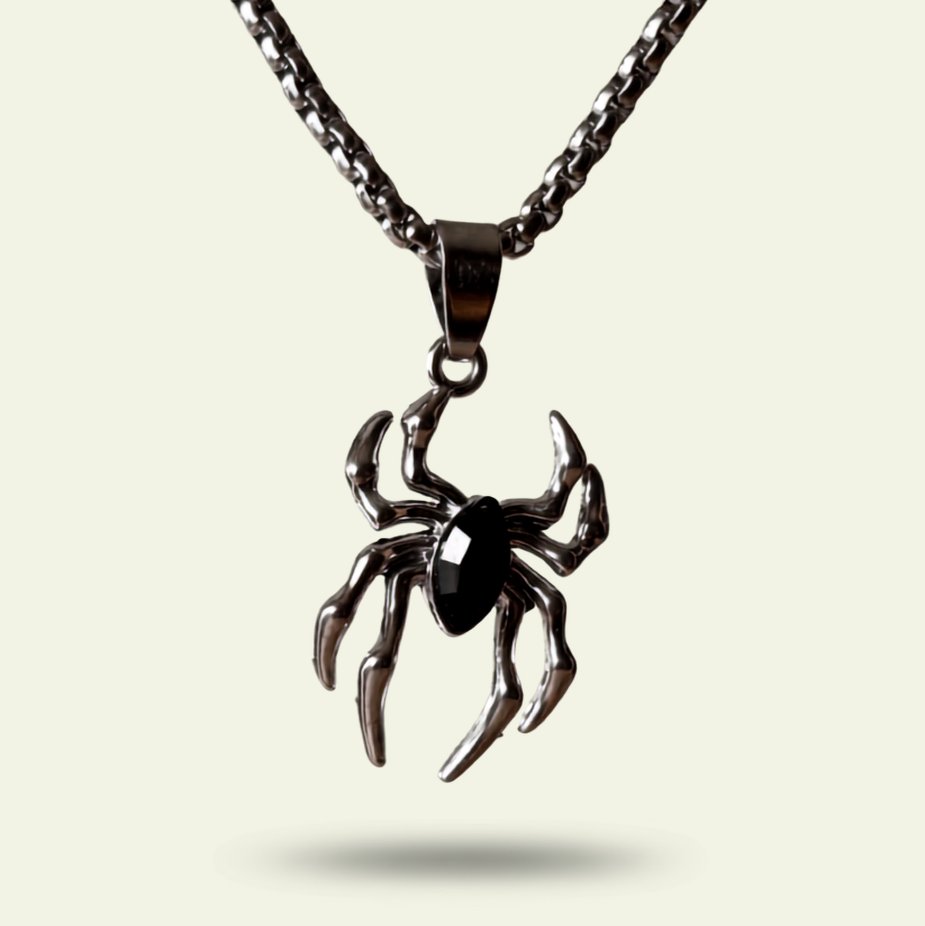 Spider-shaped pendant on a chain against a light background