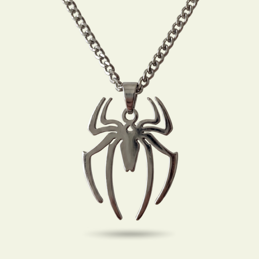 Spider-shaped pendant on a chain against a beige background
