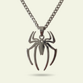 Spider-shaped pendant on a chain against a beige background