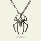 Spider-shaped pendant on a chain against a beige background