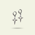 Pair of silver star-shaped earrings on a light beige background
