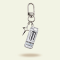 Monster energy drink can keychain on a beige background